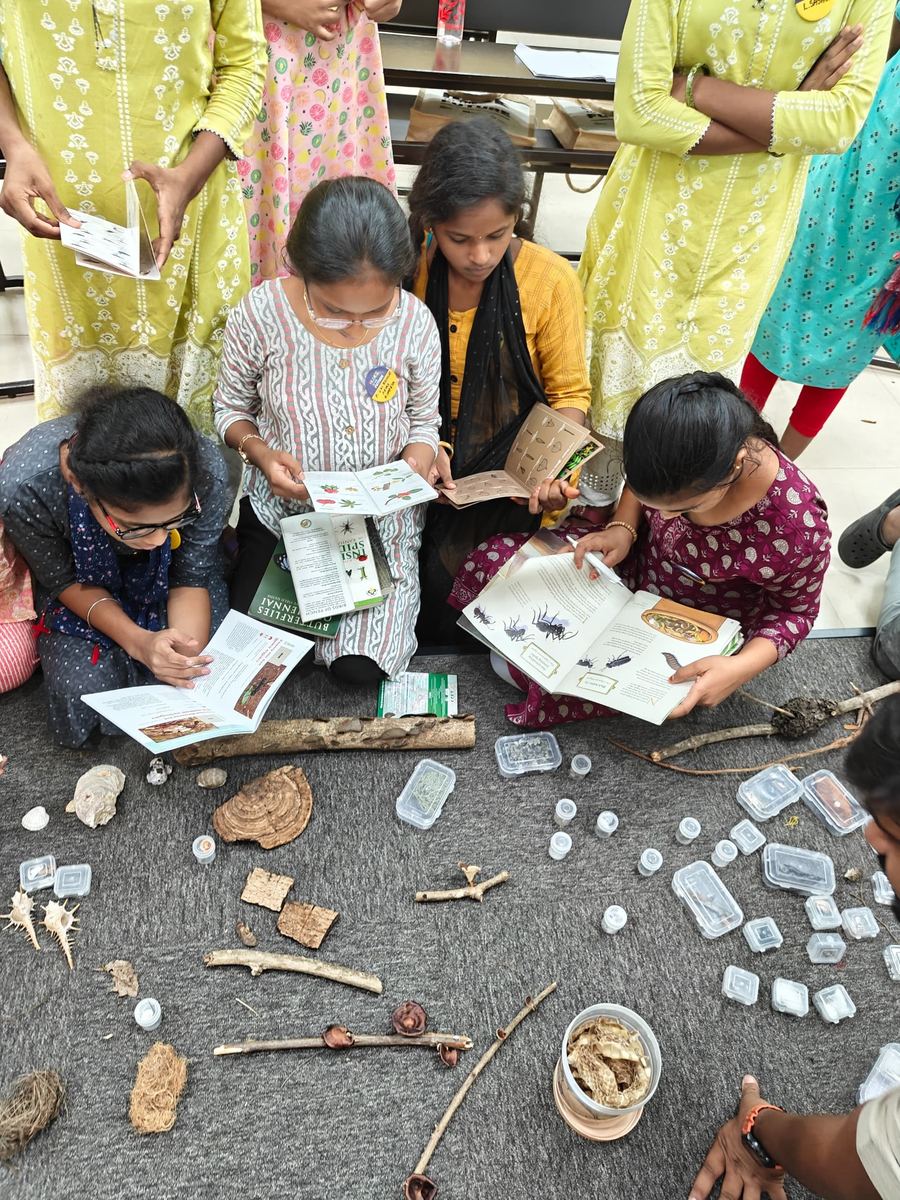 Young women read field guides beside specimens laid out on the floor